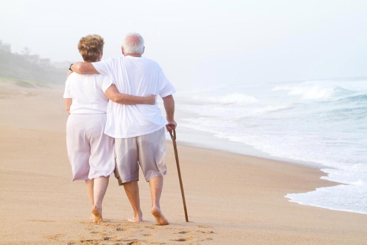 沙滩上散步的老年夫妇