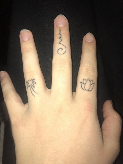 女生手指上黑色简单线条创意符号和花朵纹身图案