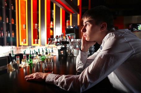 悲哀的年轻人在酒吧照片