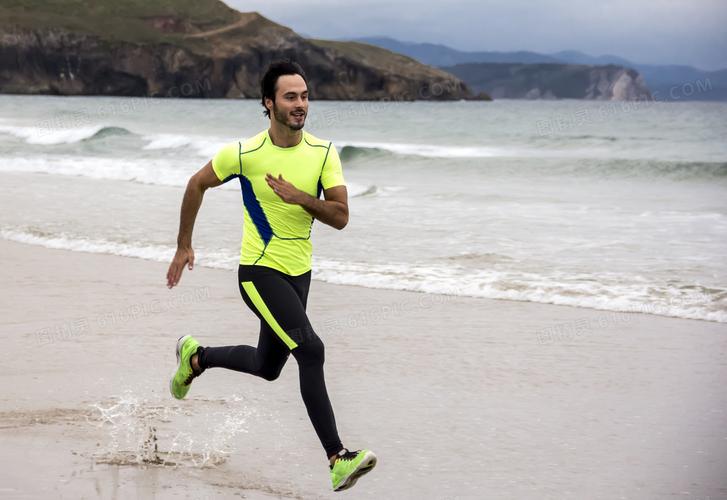 海边沙滩上跑步的男子摄影高清图片