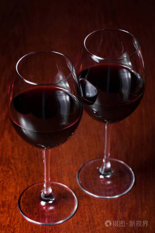两杯红葡萄酒在黑暗的背景上