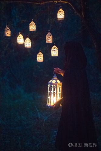 一盏灯在晚上在森林里的女孩