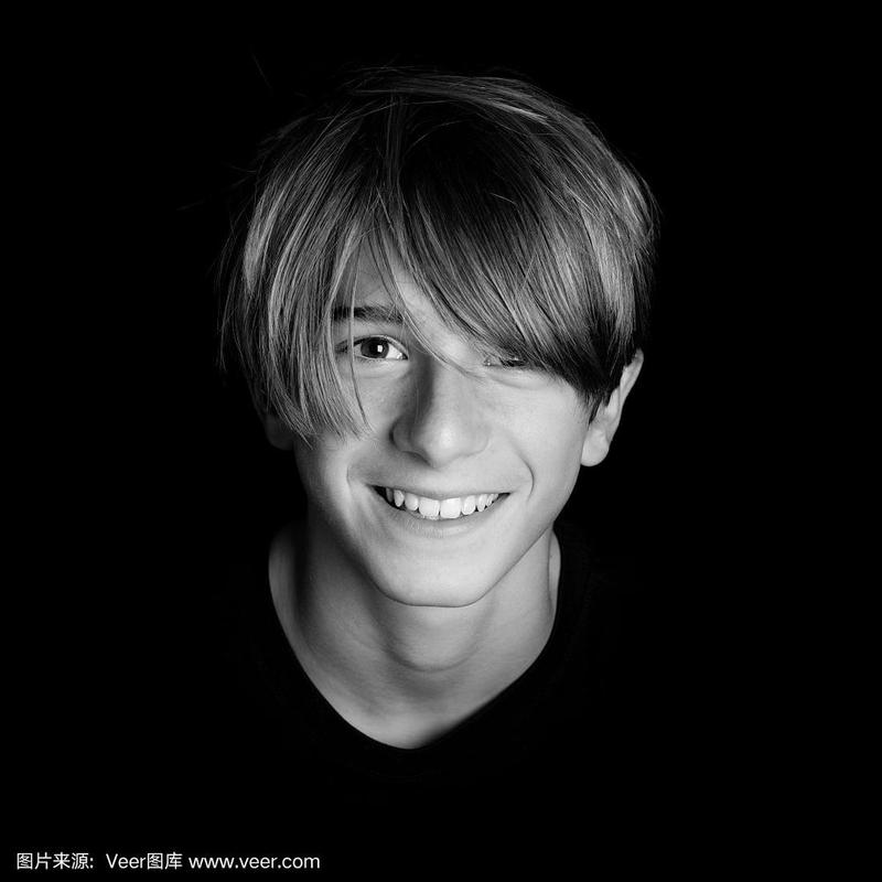 年轻的金发微笑的家伙肖像在黑色的背景-黑白照片