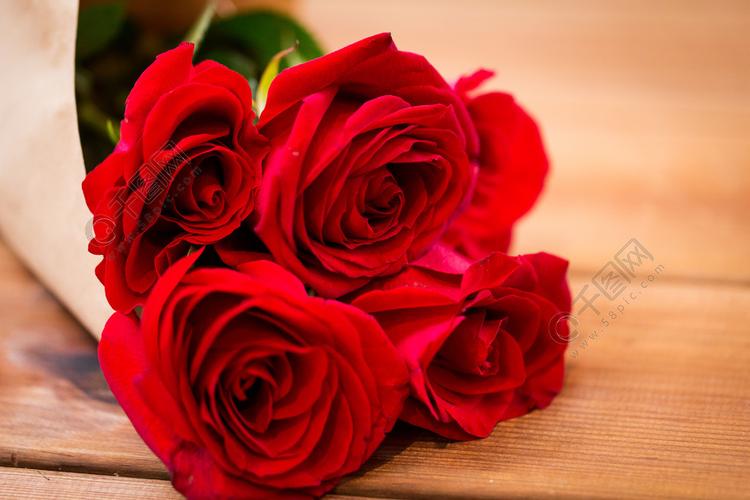 爱日期鲜花*节和假期的概念关闭的红玫瑰束包裹成棕色的纸木制的