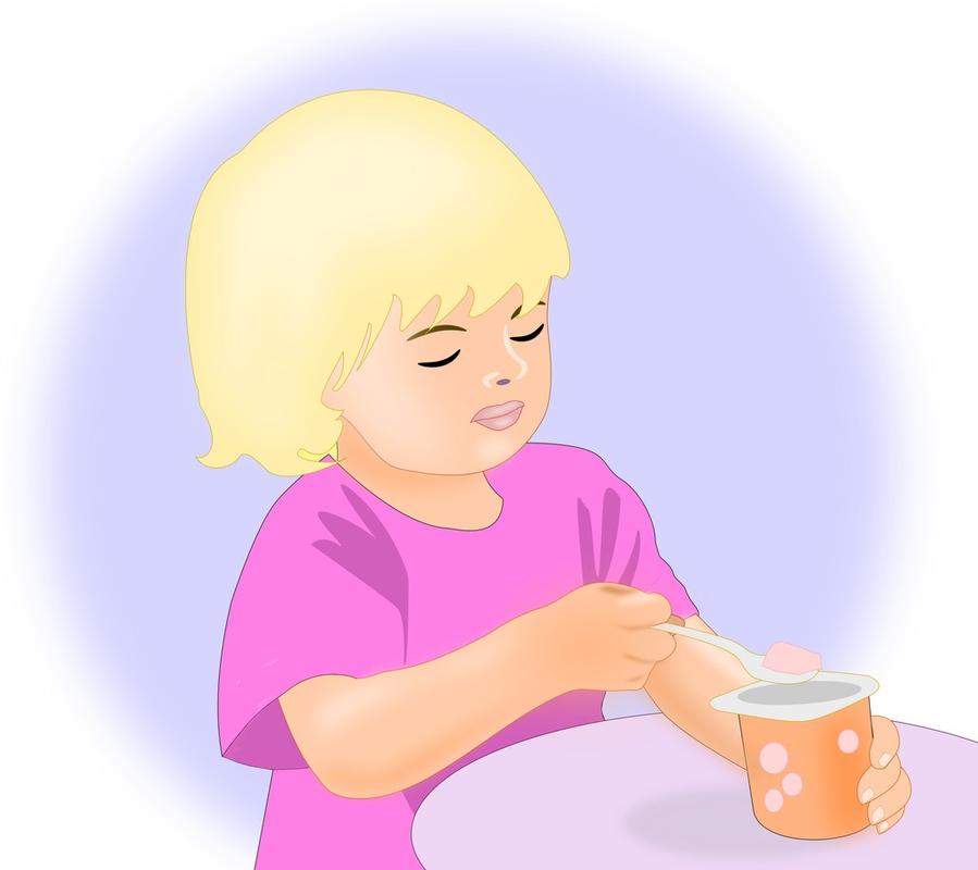 小女孩,一个小小的金发女孩吃酸奶.